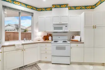Kitchen window overlooks your private side yard. Kitchen cabinets and countertops are well cared for and provide great space to cook and store.