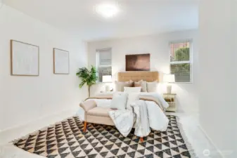 Primary suite is large, well lit and faces the privacy side yard; lovely greenery seen through the windows.