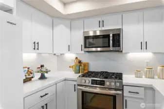 The kitchen has been updated with new quartz countertops, new shaker cabinets, new under cabinet lighting, new overhead LED lighting, and a new dishwasher.