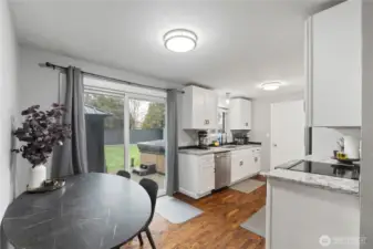 Kitchen includes updated appliances, granite counters, beautiful wood flooring.