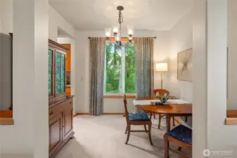Dining room looks out to a serene green space.