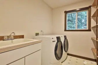 Lots of space to store your dry goods (see shelving along the right edge of photo). Deep utility sink and the hot water heater is to your back. Vinyl flooring.