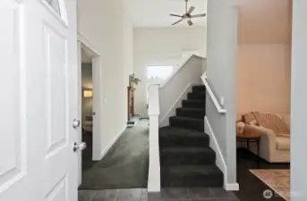 Welcome! Open door to the left is the Primary Suite, to the left of the stairs is the open family room and to the right is the formal living room or dining room which leads to the kitchen. There is a coat closet behind the opened front door.