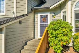 Charming front entry with a welcoming walkway, fresh greenery, and a cheerful door adorned with a seasonal wreath. The perfect first impression for this inviting home.