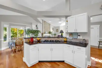 Stylish open-concept kitchen with granite countertops, white cabinetry, and a gas cooktop. Overlooks the bright dining area and living room, creating a perfect flow for entertaining and everyday living.