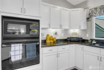 Bright and functional kitchen with granite countertops, white cabinetry, and built-in appliances. Ample counter space and under-cabinet lighting make it both stylish and practical for everyday cooking.