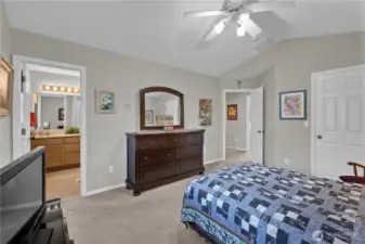 A comfortable and airy primary suite with vaulted ceilings, neutral tones, and an en suite bath. Warm natural light and classic finishes make this space both relaxing and inviting.