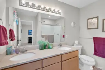 Spacious bathroom featuring a double vanity, large mirror, and a combination tub and shower. Clean lines and neutral tones create a fresh, modern feel.