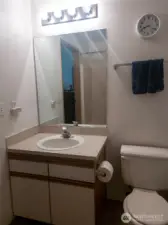 A large mirror and bright overhead lighting make the vanity area feel open and functional, providing plenty of room for getting ready and organizing essentials.