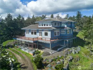 Walls of glass and generous decking frame breathtaking water views, while thoughtfully designed garden spaces enhance the home’s connection to the landscape.