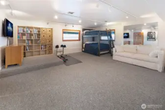Expansive lower-level flex space ideal for guests, recreation, or wellness, featuring bunk accommodations and room for a home gym or media area.