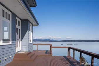 Expansive waterfront deck designed for indoor-outdoor living, offering front-row seats to sunrise skies, passing boats, and peaceful island views.