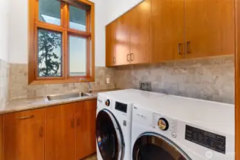 Well-designed laundry room with ample cabinetry, utility sink, and workspace—bringing both function and organization to daily living.