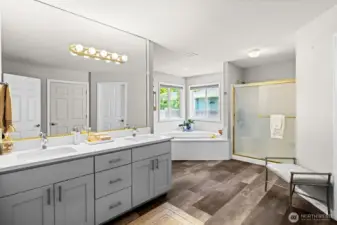 Primary retreat with full bath en suite, dual sink vanity, jetted tub, and private lavatory.