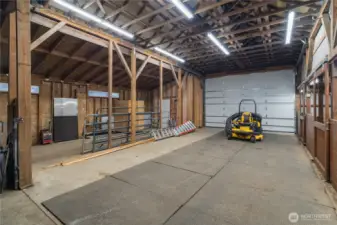 Interior of barn with plenty of room for horse trailer parking, hay storage, and even the ability to add more stalls!