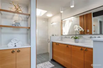 Primary luxury bathroom.  Slate flooring, skylights, stylish cabinets with vintage hardware.  Heated floors flow from bathroom to primary bedroom.