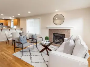 Bright and cozy living room with a gas fireplace and a balcony with territorial views