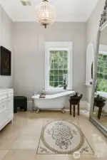 The main floor bathroom features mosaic tile inlay and a claw foot soaking tub. Across the hall you will find a charming powder room.