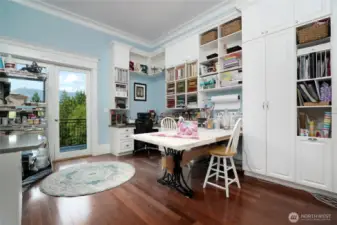 Ensuite bedroom, currently set up as a fabulous craft room, has French door access to balcony, sink, built-ins, closet and a full bathroom.