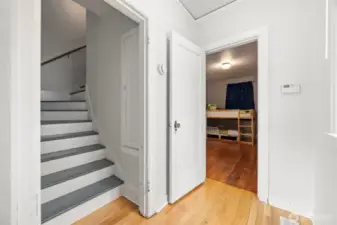 Stairway leading to the upper floor where there is a full bathroom and two additional bedrooms.