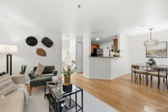 Open-concept layout connects the living, dining, and kitchen areas with hardwood floors throughout and easy flow to all spaces.