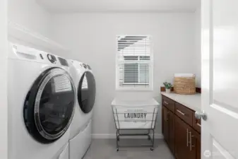 The convenient upstairs laundry room offers built-in storage cabinetry and a folding counter. Full capacity front load washer and dryer with pedestals are included!