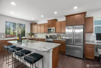 The expansive center island offers ample prep space, seating for four, and an under-mount sink including a filtered alkaline drinking water faucet - perfect for hosting guests or enjoying casual meals.