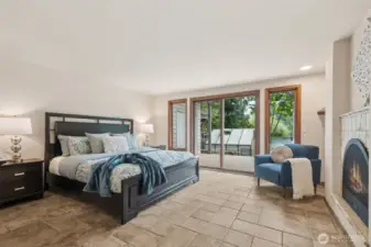 Main floor primary suite, with gas fireplace, heated tile floors, slider out to deck, with expansive lake views!