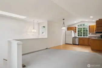 Open, lofted living room + kitchen . . . good lighting, skylight & windows.