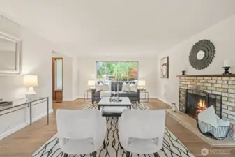 The living room is elegantly designed with a large picture window that brings in ample natural light to create a warm and inviting atmosphere. It's the ideal space for spending cozy evenings at home, especially next to the charming fireplace.
