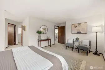 The Primary Suite features new carpet, a spacious layout with room for a seating area, and direct access to the en-suite bath. A functional flow and neutral palette create a comfortable retreat.