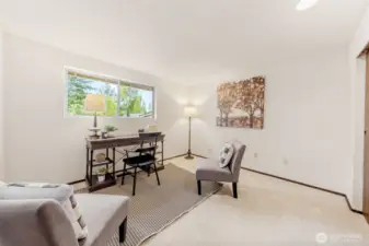 Bedroom One, features wall-to-wall carpeting, updated paint, and a generously sized closet. The large picture window adds natural light and a view of the outdoors.