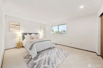 Bedroom Two, features wall-to-wall carpeting, updated paint, and a generously sized closet. The large picture window adds natural light and a view of the backyard.