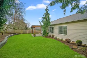 Easy-care yard with lawn and established landscaping.