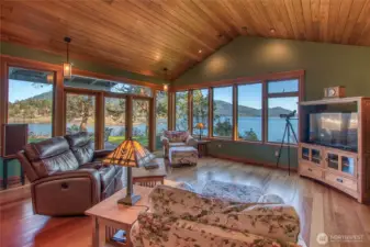 Main level open floor plan includes kitchen/dining and living space. All surrounded by large windows and glass french doors. Buck Mountain and Mt Constitution in the background. Brazilian cherry floors throughout.