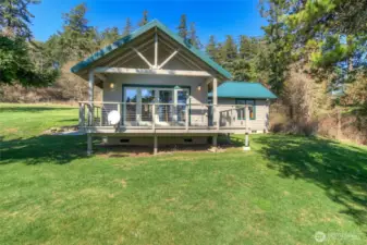 Guest house as seen from the water side of the property. Wrap-around deck offers outdoor space and access to the level yard.