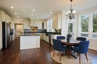 You can see the spacious laundry room in the distance, straight ahead. The walk-in-pantry is to the right of the laundry room. Garage access is to the left of the laundry room. Note another access to your deck from the glass door beyond the kitchen table.