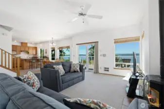 Open concept living area has high ceilings, lots of natural light & a wall of windows to a gorgeous water & mountain view.