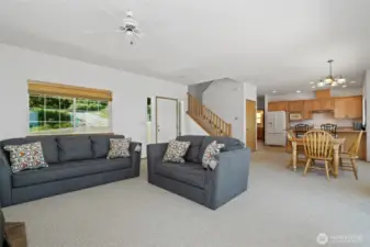 Open concept living area has high ceilings, lots of natural light & a wall of windows to a gorgeous water & mountain view. Main floor bedroom & laundry. Stairs lead to 2 bedrooms & a full bath.