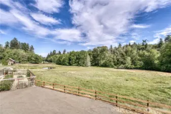 Pasture views from the back deck. The raised bed fenced garden is on the left.