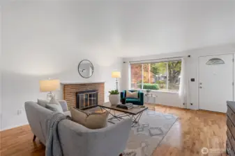 The cozy and relaxing living room illuminated by bright natural light through the large windows creates an ambiance of comfort and tranquility.