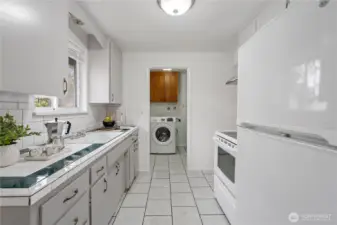 The bright and airy kitchen with tiled countertops, ceramic tiled flooring and a large window for great natural light.