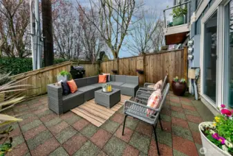 Private patio is surrounded by trees and has space for couches, planters and BBQ.