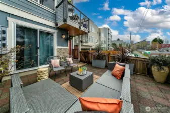 Private patio is surrounded by trees and has space for couches, planters and BBQ.