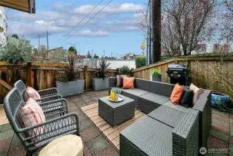 Private patio is surrounded by trees and has space for couches, planters and BBQ.