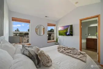 Lovely view of the primary bedroom windows and entry to the primary bathroom with double vanity, soaking tub, large walk-in-shower and linen closet.