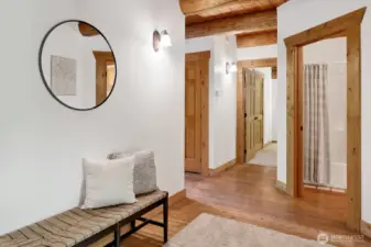 Wood flooring is accented by the white walls