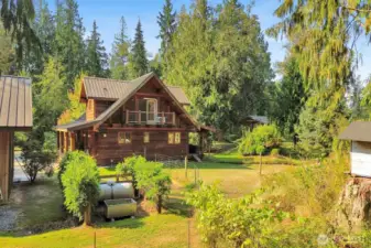 The property features lovely landscaping including fruit trees and a fenced garden area with berries