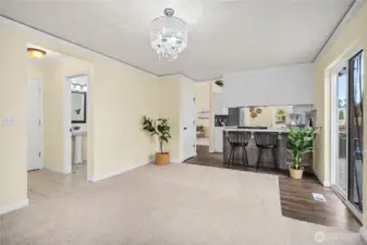 This perspective emphasizes the room’s versatility, with direct access to the half bath, kitchen, and outdoor area. Carpeted comfort and crown molding combine for a warm yet refined atmosphere.