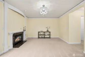 This angle highlights the gas fireplace as the focal point of the family room. Neutral wall tones and crown molding create a polished look, while the open layout ensures flexibility for furniture placement.